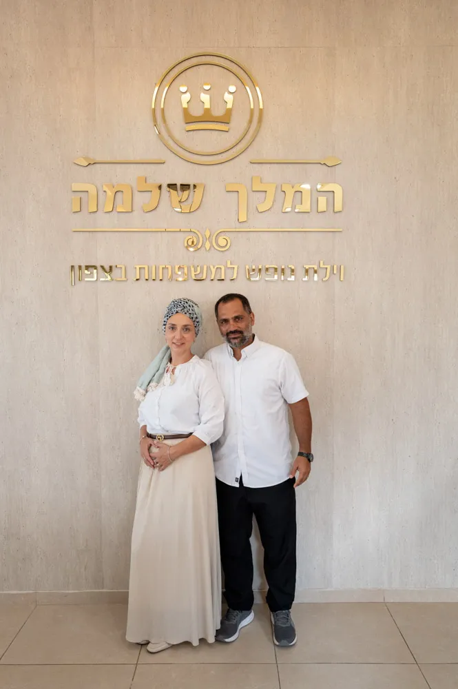 פאני ואיתי, המארחים של וילת המלך שלמה, מול לוגו האחוזה